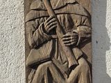 une sculpture représentant un homme jouant de la flûte, sur le mur
