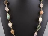 a necklace with multi colored glass beads on a mannequin