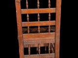 a wooden chair that has a basket on the back of it
