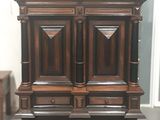 une armoire en bois à deux portes, surmontée d'une étagère