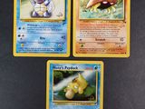 three pokemon cards are sitting on a table with a black background