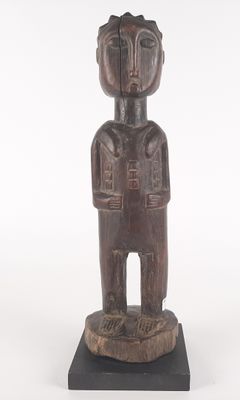 an old wooden statue of a man standing on top of a wooden base