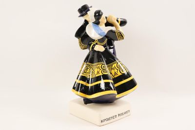 a close up of a figurine of a woman in a black and gold dress
