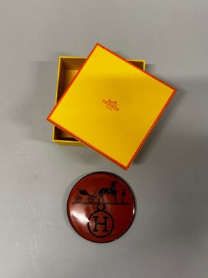 une boîte orange avec un couvercle jaune et un petit bouton rouge sur lequel figure un personnage de dessin animé