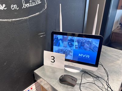 a computer monitor sitting on a table in front of a chalk board