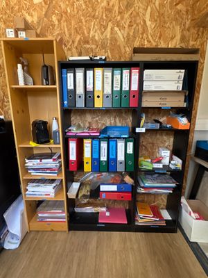 une bibliothèque remplie de nombreux livres et classeurs