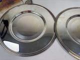 two silver plates sitting on a white table