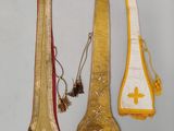 trois morceaux de tissu doré et blanc ornés d'une croix