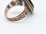 a close up of a ring with a black stone in it