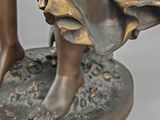 bronze statue of a woman with a basket of flowers on her head