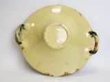 a yellow vase with a handle on a white surface