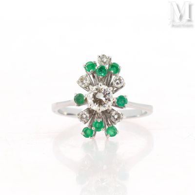 an image of a diamond and emerald flower ring on a white background