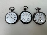 trois types différents de montres de poche exposées sur une table