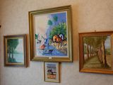 many paintings hanging on the wall of this room