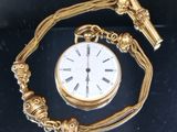 une montre de poche dorée, attachée à une chaîne