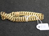 gros plan d'un bracelet en chaîne en or avec une étiquette de prix