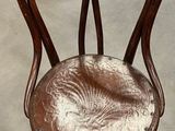 a wooden chair with a brown seat in a room