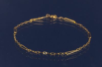 un bracelet en chaîne dorée sur un fond noir