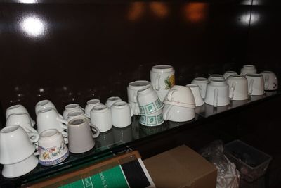 a lot of coffee cups on a shelf in a room