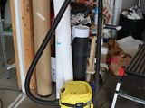 un aspirateur jaune qui est rangé dans un garage