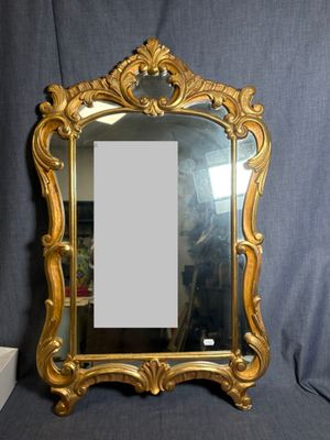 une image représentant un miroir à cadre doré posé sur un tissu bleu