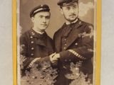 une vieille photo montrant deux hommes en uniforme debout l'un à côté de l'autre