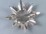 a silver brooch with a mirror in the middle of it