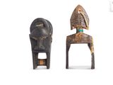 pair of african carved wooden chairs with a head on the back
