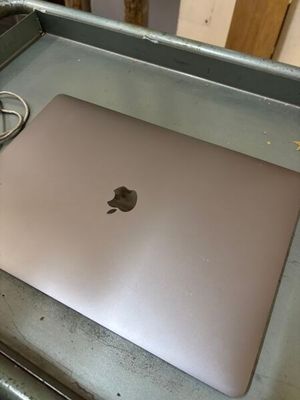 un ordinateur portable posé sur une table en métal