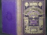 an old book with a purple cover sitting on top of a table