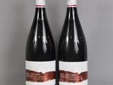 two bottles of wine sitting on top of a table next to each other