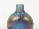 un vase bleu et violet posé sur une surface blanche
