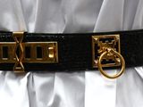 a woman wearing a belt with a gold buckle on it