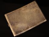 an antique silver cigarette case on a black background