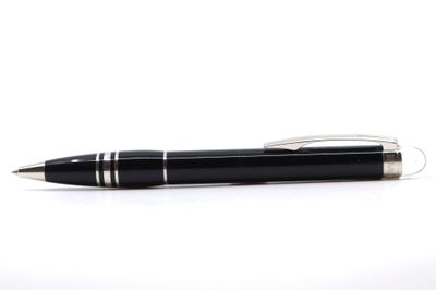 stylo à bille sur fond blanc, avec des bouts de papier à son extrémité