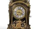 a gold clock that is sitting on a white surface