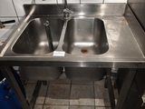 a stainless steel sink with two sinks in it