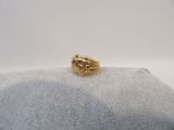 gros plan d'une bague en or sur une surface blanche
