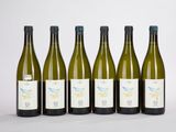 six bouteilles de vin blanc sont alignées