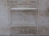 a white metal shelf with three shelves on it