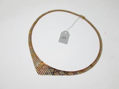 un collier muni d'une étiquette, posé sur une surface blanche