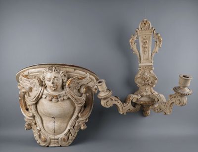 pair of antique wall sconces with ornate carvings and a candle holder