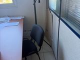 a desk with a chair and a coat rack in the corner of the room