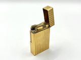 a gold lighter that is sitting on a white surface