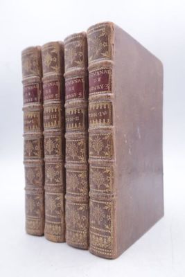 quatre vieux livres sont empilés les uns sur les autres sur une surface blanche
