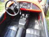 a red and black car with a steering wheel and dashboard