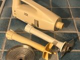 a yellow hand blender on a tiled floor next to a sink