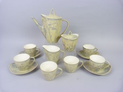 many cups and saucers and a teapot on the table
