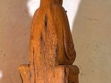 a wooden sculpture of a bear sitting on a tree stump