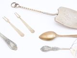 a lot of silver and silverware on a white surface